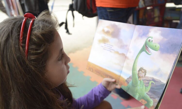 Criança lê livro na tenda da Flipinha (Foto: Reprodução/Agência Brasil)